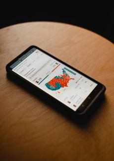 black android smartphone on brown wooden table by Clay Banks courtesy of Unsplash.