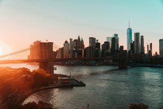 brown bridge over river near city buildings during daytime by Magnus Andersson courtesy of Unsplash.