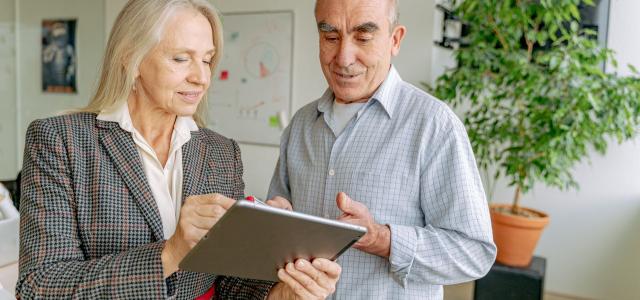 Professionally dressed man and woman looking at a tablet